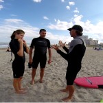 Guy talking to two people about surf instructions