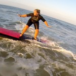 girl with tattoo learns to balance on surfboard