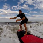 man surfing on red and black surfboard
