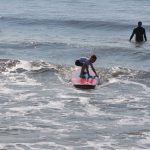 Little boy almost standing up on surfboard