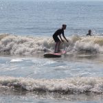 young man surfing several waves