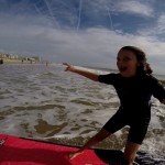 Girl surfing in shallow water looking at camera close up