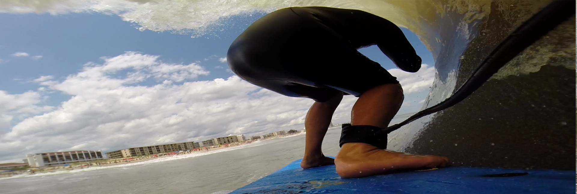 POV from behind surfer as they surf through a wave
